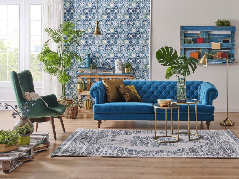 blue couch and green armchair in a living room with gray rug and brown hardwood floor from Stoller Floors in Orrville, OH